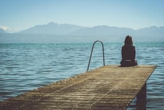 women sitting on the end of a pier